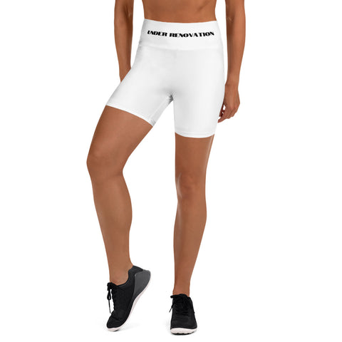 A partial view of a young woman wearing white yoga leggings with the words "Under Renovation" written in black bold letters.