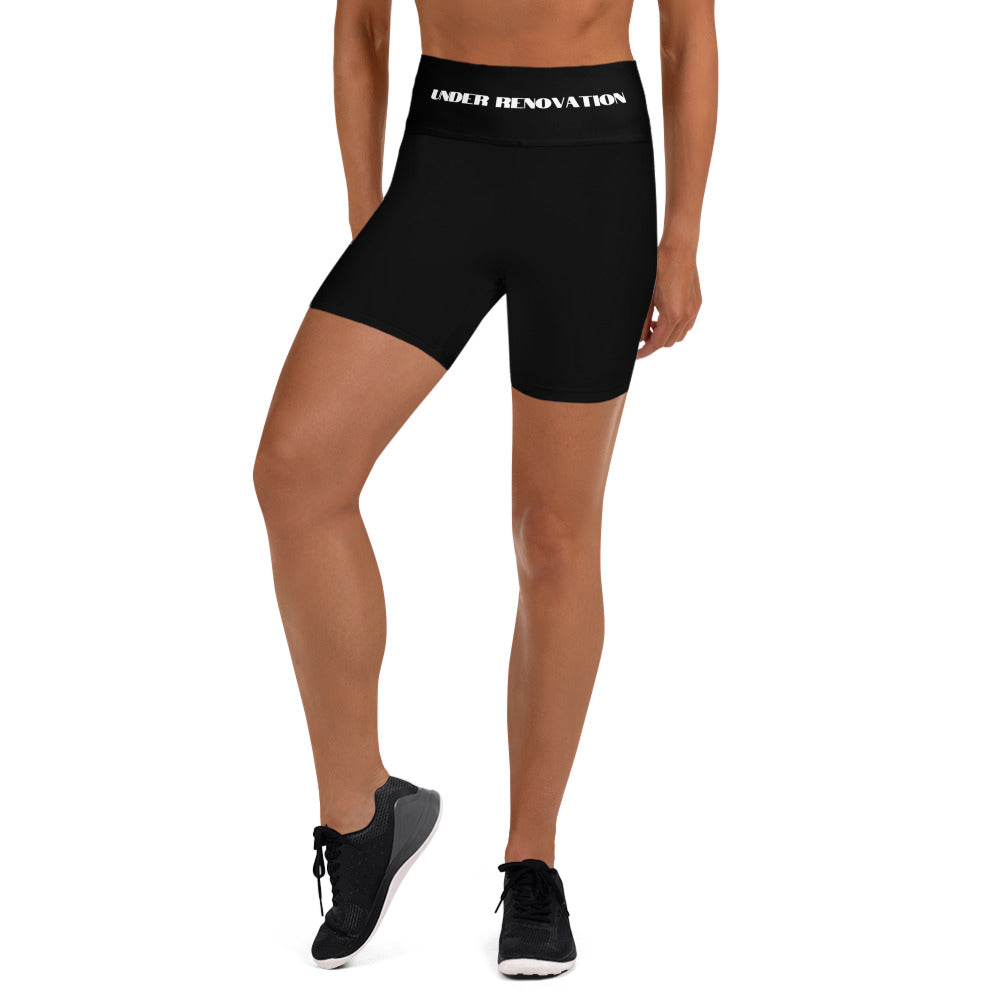 A partial view of a young woman wearing black yoga leggings with the words "Under Renovation" written in white bold letters.